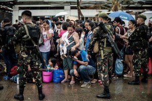 Varios sobrevivientes esperan en fila listos para abandonar la ciudad en Tacloban.  Foto:  AFP 