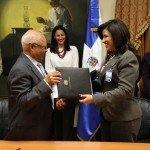 La vicepresidenta Cedeño de Fernández y el doctor Cuello Nieto de Flacso intercambian carpetas.