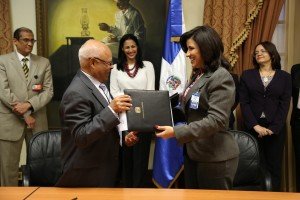 La vicepresidenta Cedeño de Fernández y el doctor Cuello Nieto, de Flacso, intercambian carpetas.