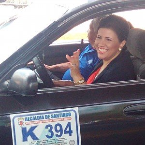 La Vicepresidenta Margarita Cedeño saluda a los  transeúntes mientras conduce un carro público en Santiago.